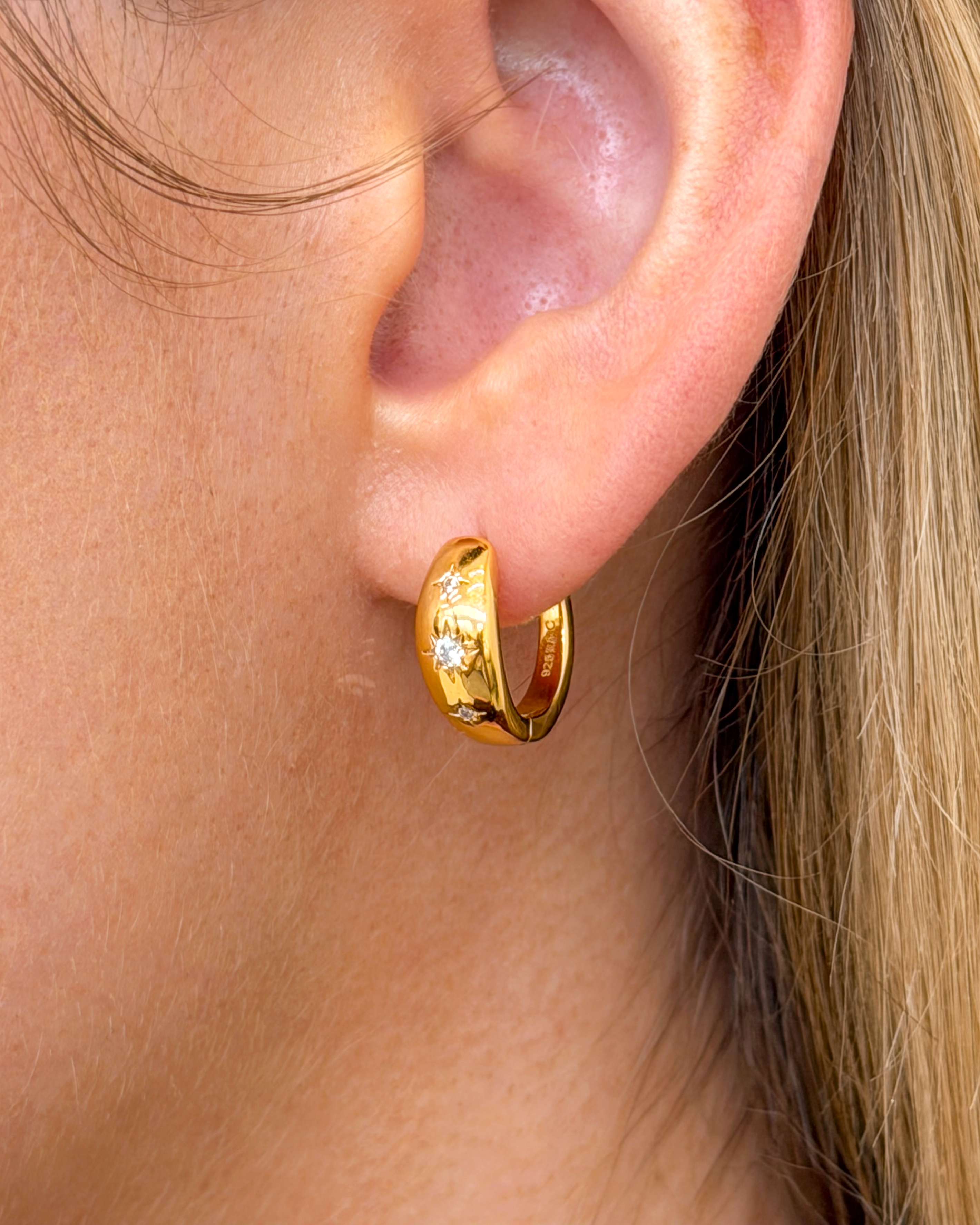 Delicate 20mm gold hoops featuring triple CZ star dangles – sparkling star-themed earrings