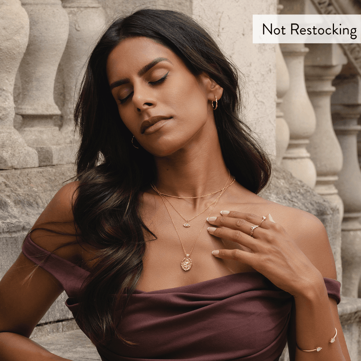 Limited Edition Goddess Saraswati Blue Topaz Necklace worn with layered gold jewellery and elegant occasion styling.