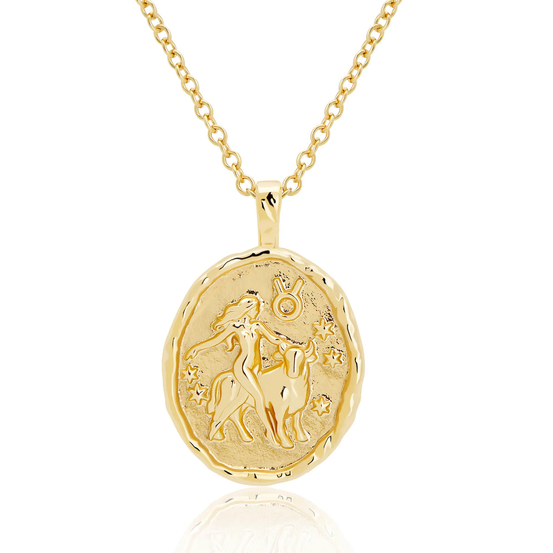 Gold necklace with a taurus zodiac pendant on a white background