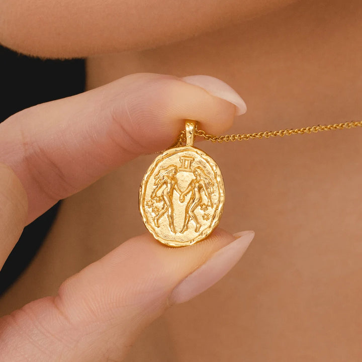 Gold Gemini horoscope necklace with twin zodiac symbol and constellation stars on round coin pendant astrology jewellery
