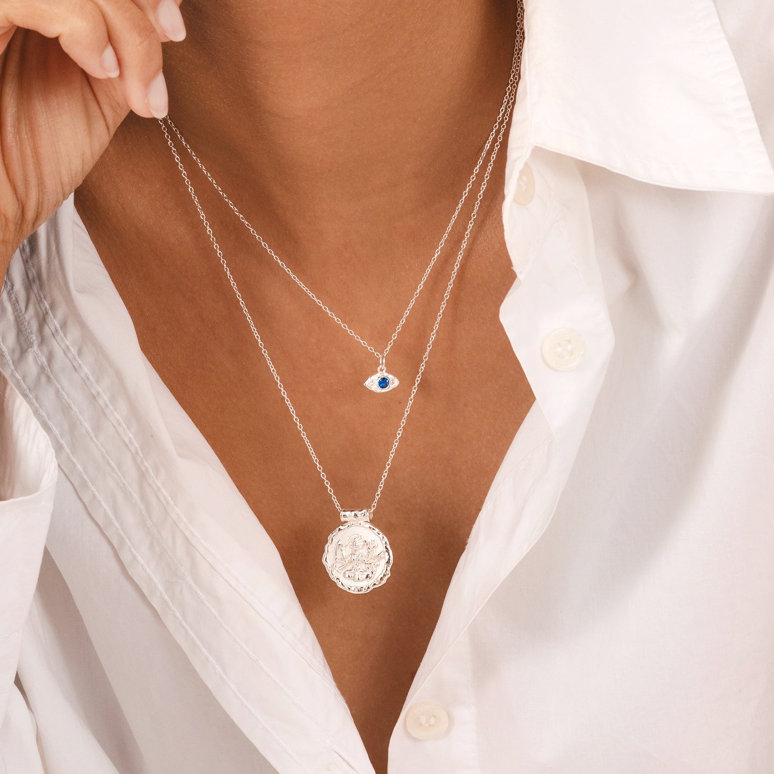 Organic molten-texture evil eye necklace in silver with blue stone, Rani & Co.