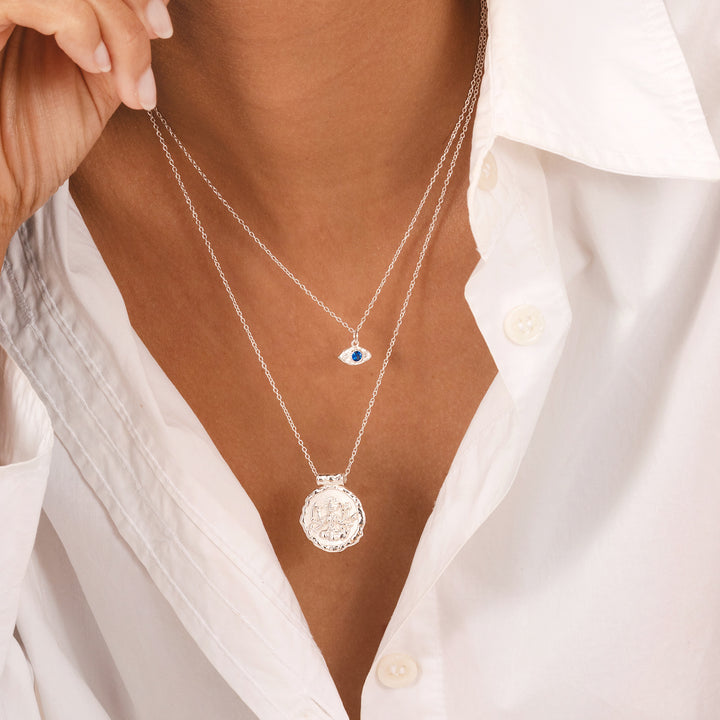 Organic molten-texture evil eye necklace in silver with blue stone, Rani & Co.