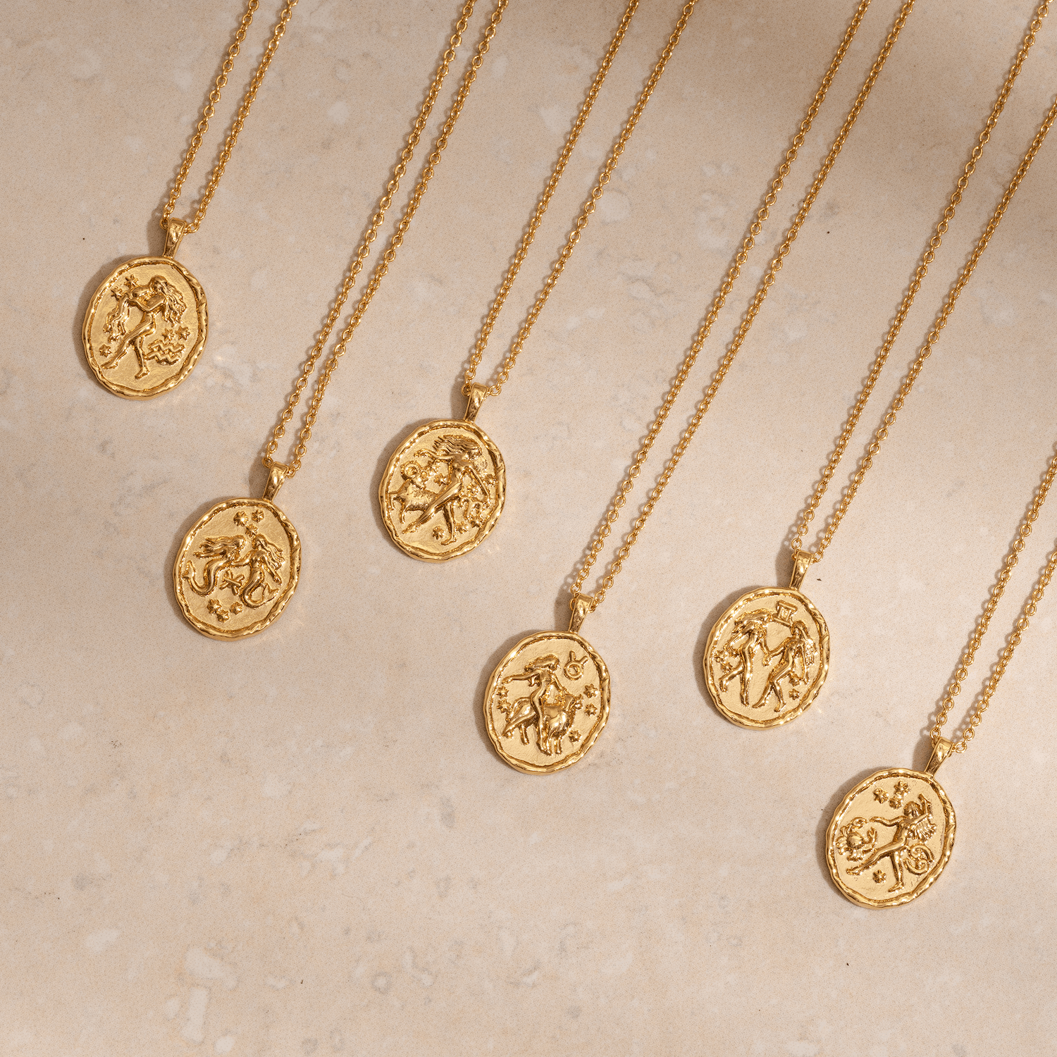 Gold zodiac coin pendant necklace collection with astrology star sign symbols on round medallion pendants astrology jewellery
