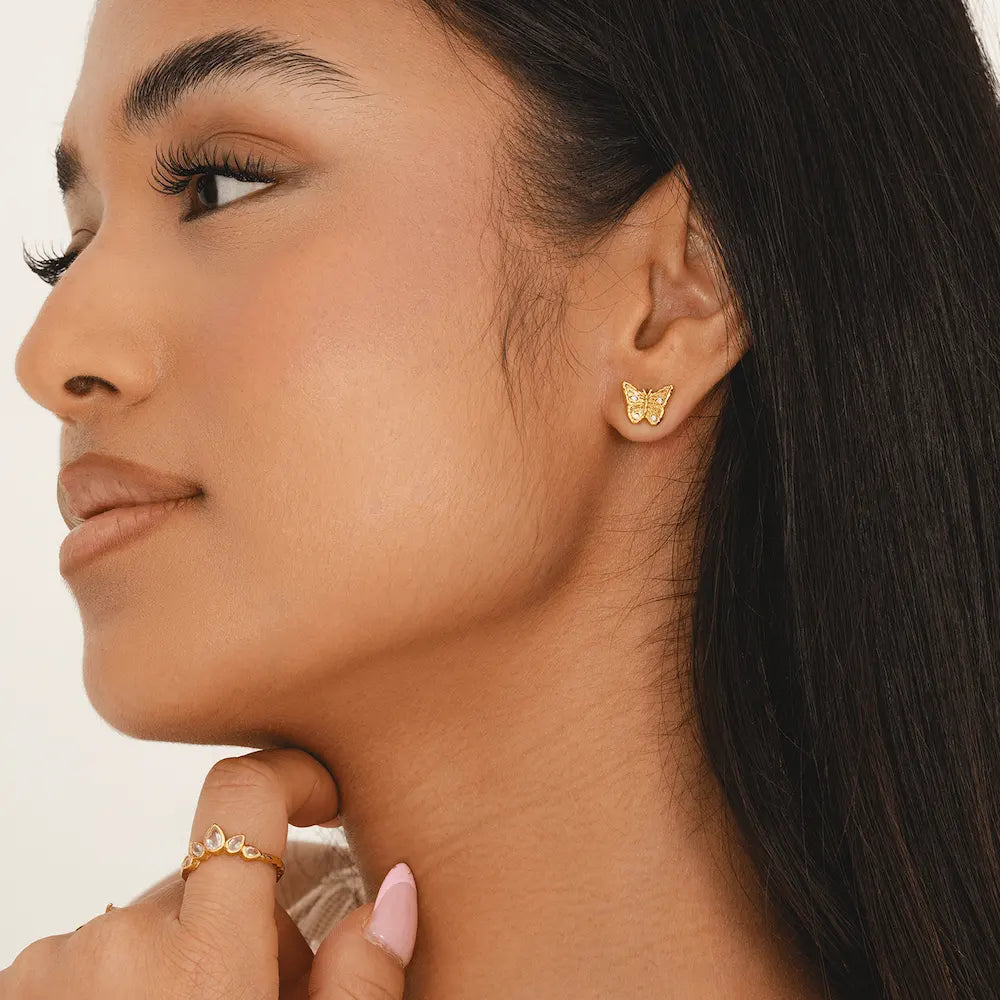 18k gold-plated butterfly stud earrings with cubic zirconia accents on model