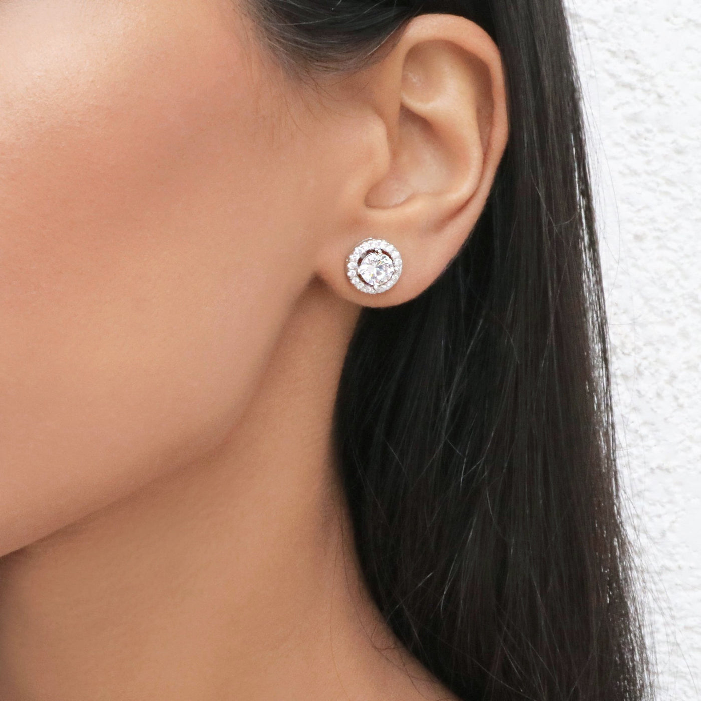 Close up of woman wearing a silver cubic zirconia 10mm stud circle round earring.
