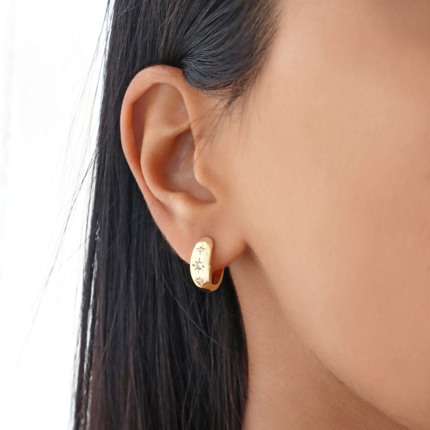 Dainty minimal small thick gold hoop earrings with 3 cubic zirconia stars. 18k gold-plated copper.